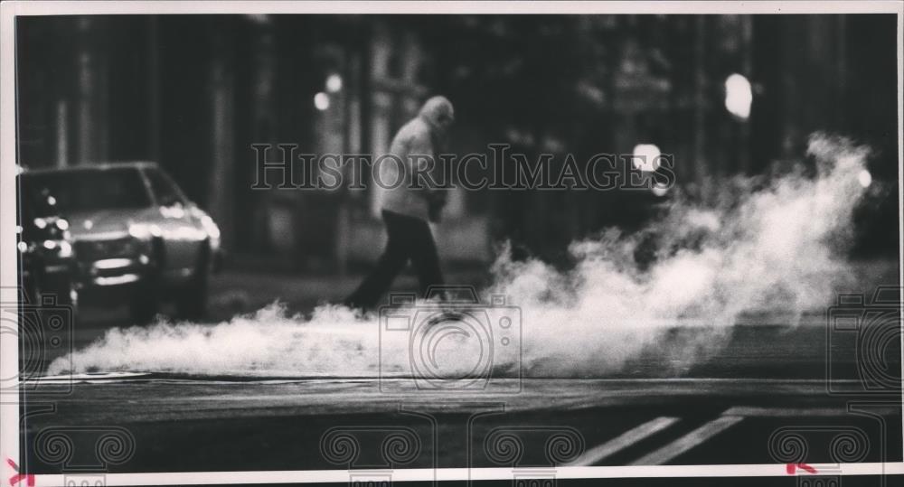 1988 Press Photo Man walks by steamy manhole cover on 21st street - abna17633 - Historic Images