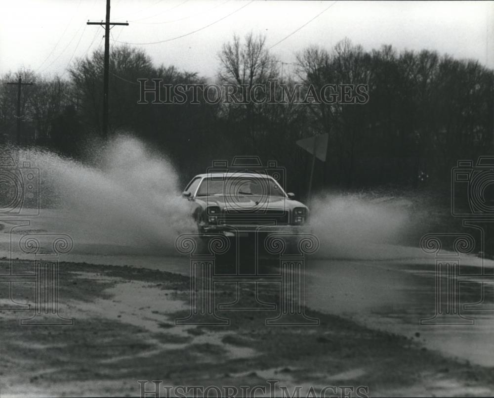 1980 Press Photo Car sends water flying on Laurel Avenue, Alabama - abna17672 - Historic Images