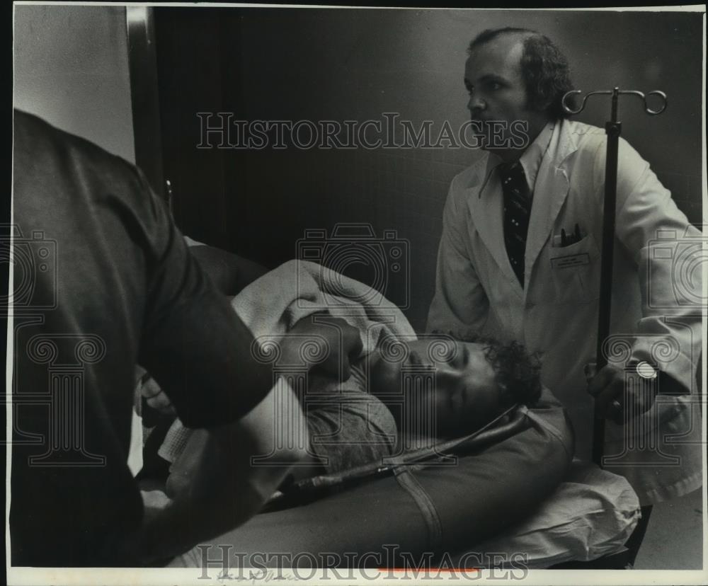 1976 Press Photo Thomas Narepa, diver, on gurney with doctor St. Luke&#39;s Hospital - Historic Images