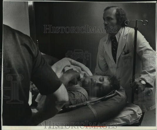 1976 Press Photo Thomas Narepa, diver, on gurney with doctor St. Luke's Hospital - Historic Images