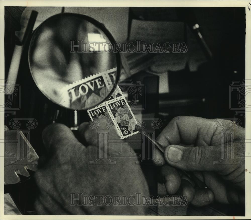 1988 Press Photo A Philatelist using tweezers and magnifying glass on stamps - Historic Images