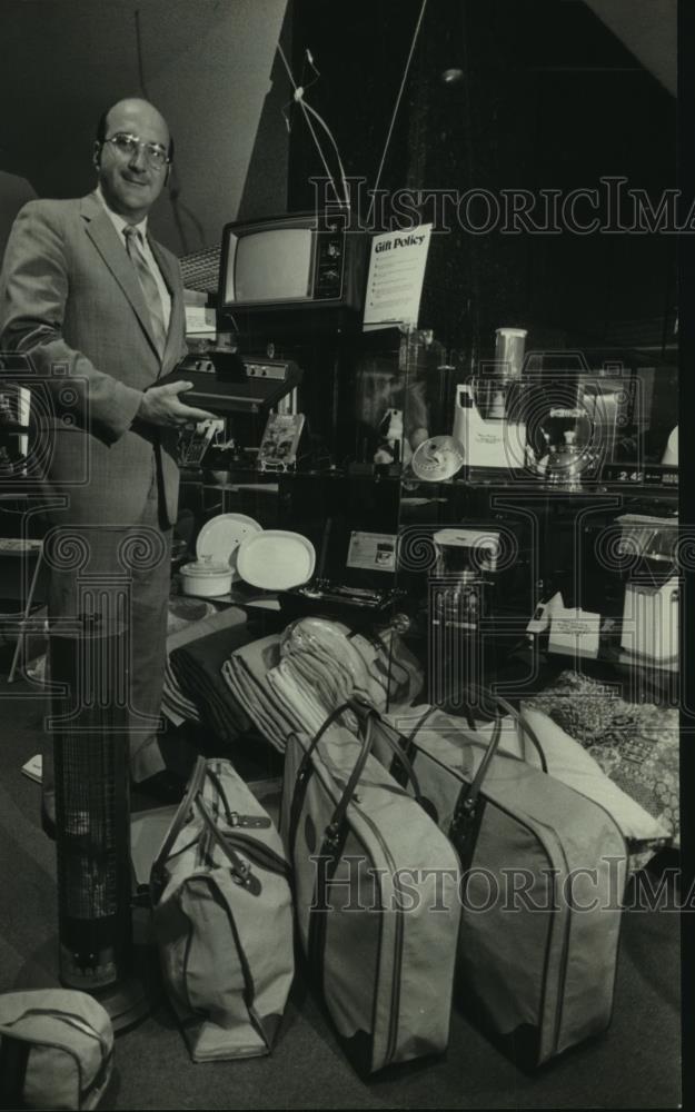 1982 Press Photo John Schmidtke, officer of Security S&amp;L, examined premiums - Historic Images