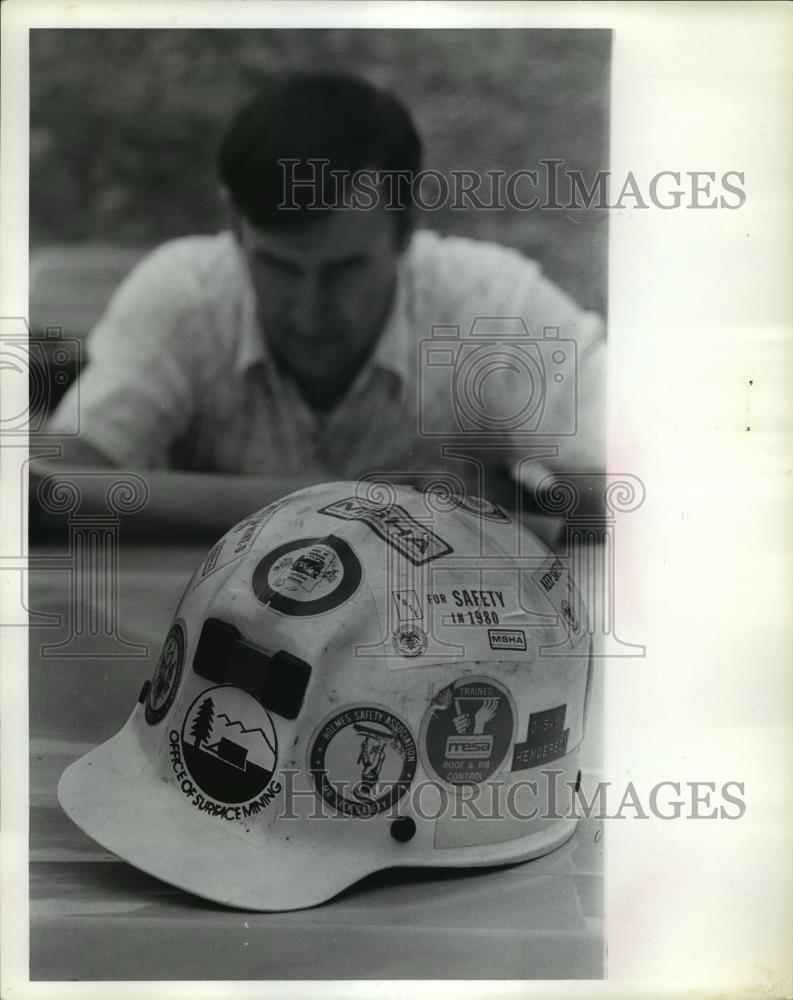 1980 Press Photo Hard Helmet with Stickers and Man in Background, Strip Mining - Historic Images