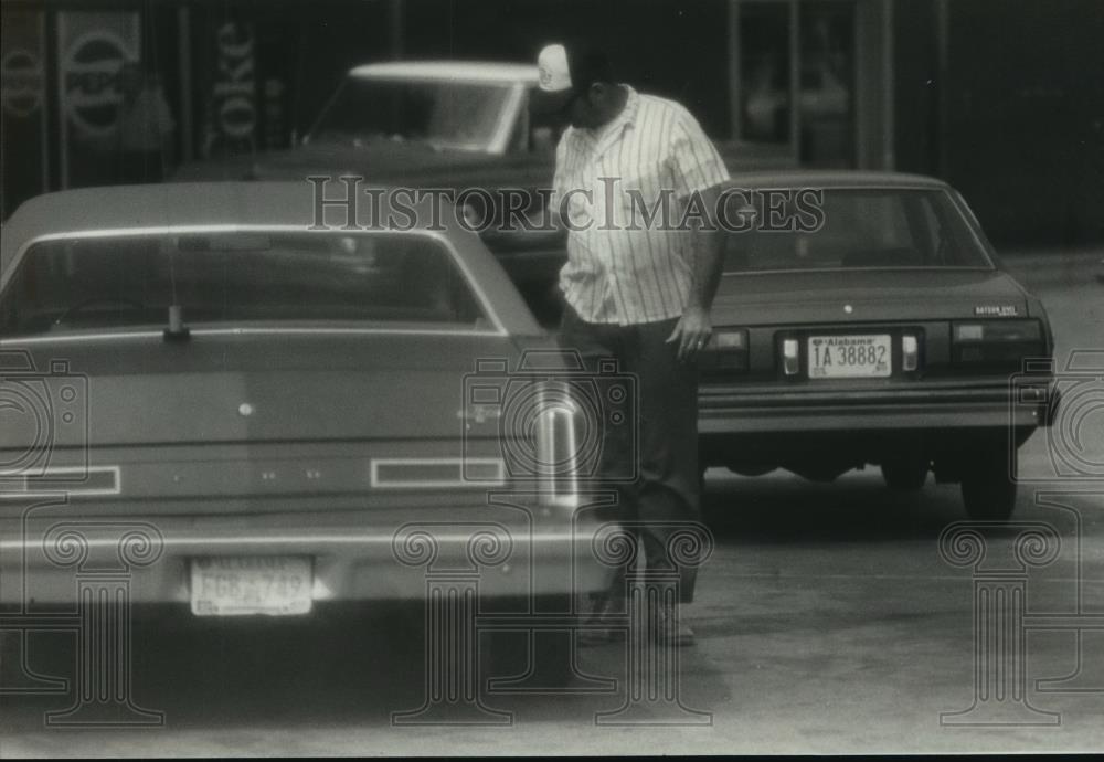 1982 Press Photo R. J. Bates puts money in Sheriff's car - abna20381 - Historic Images