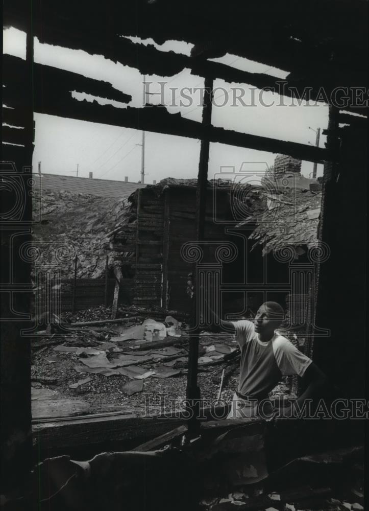 1981 Press Photo Kelvin McKeithen examines rubble from a recent arson in Ensley - Historic Images