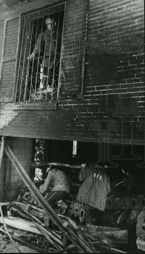 1980 Press Photo Fireman at Site Looks Through Bars Which Trapped Victims - Historic Images