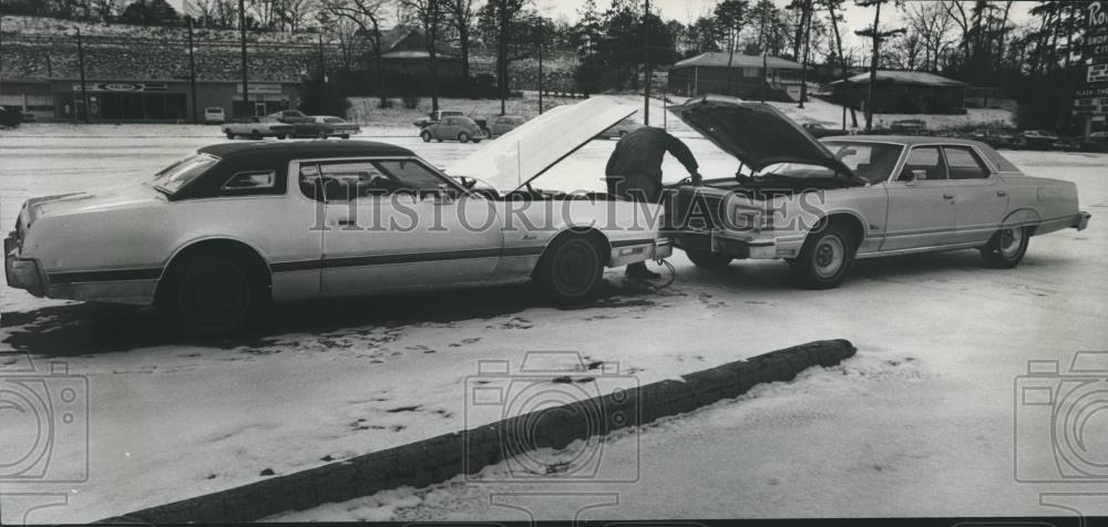 1978 Press Photo Man charges car battery with another car on snowy street - Historic Images