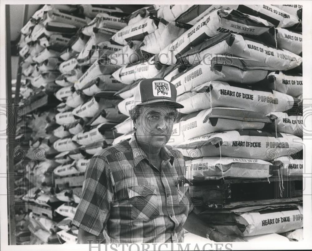 1989 Press Photo Sam Darwin beside stacked bags of Heart of Dixie popcorn - Historic Images