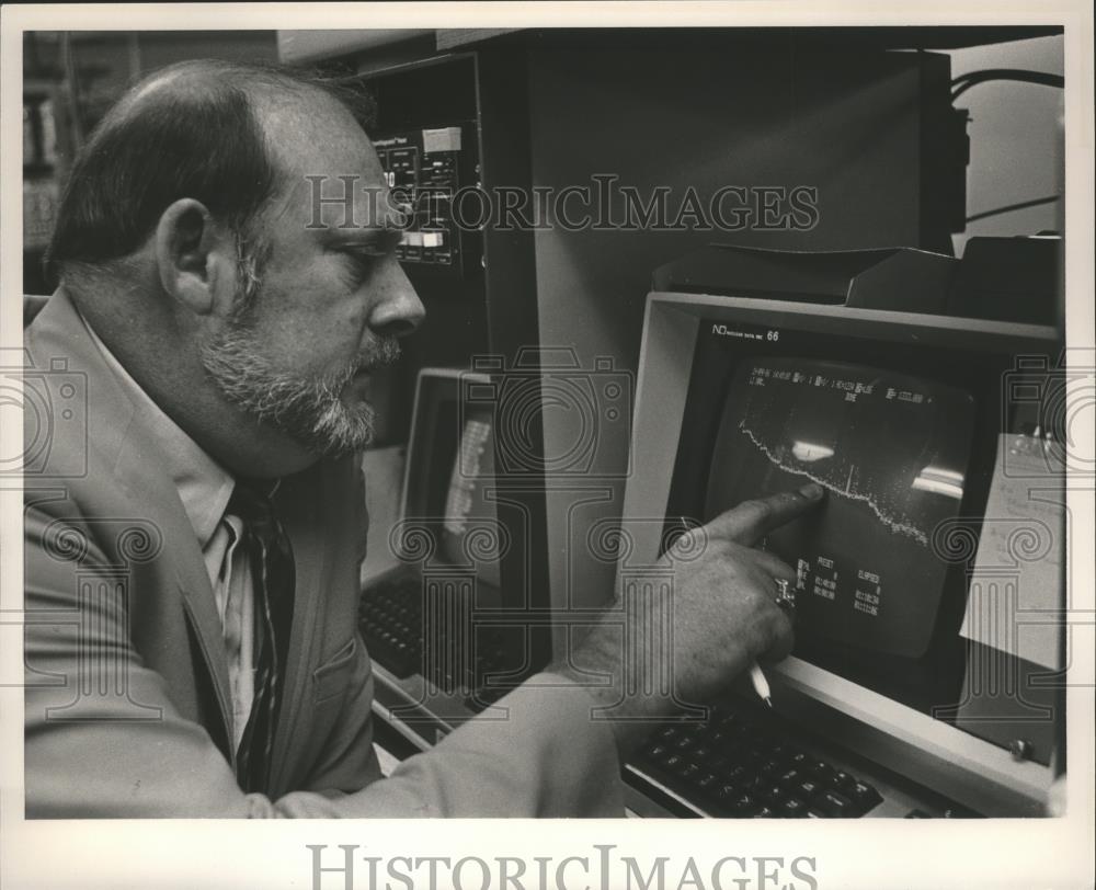1986 Press Photo Charles Porter reviews computer results at radiation facility - Historic Images