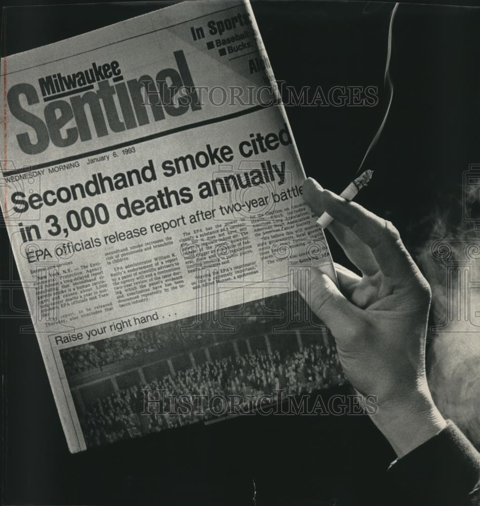 1993 Press Photo Smoker With Cigarette and Newspaper About Smoking in Hand - Historic Images