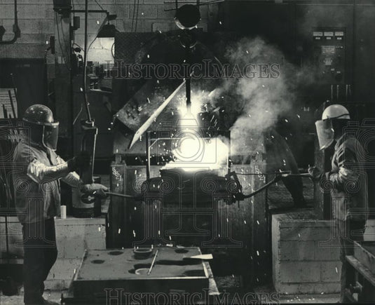 1985 Press Photo Men pour molten alloy in molds, Stainless Foundry & Engineering - Historic Images