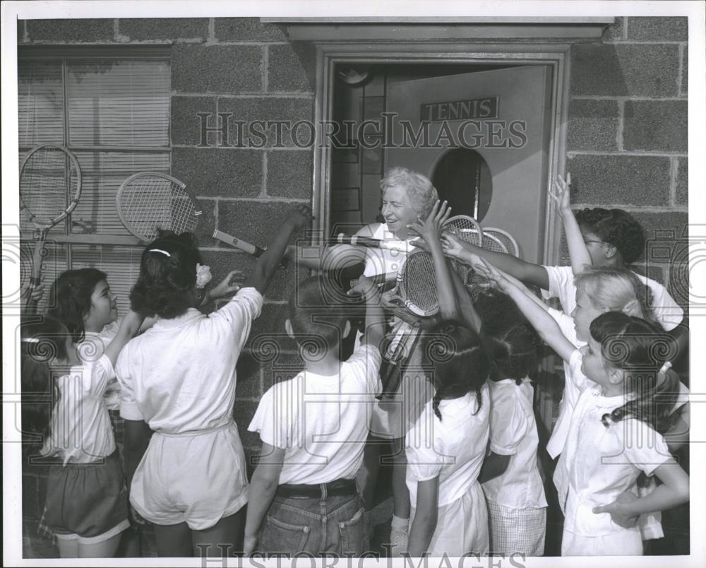 Press Photo Woman Handing Tennis Rackets Children - RRQ19897 - Historic Images