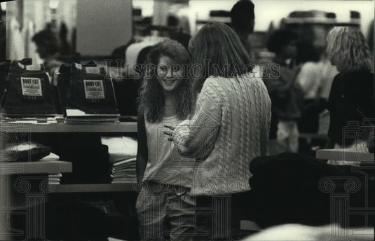 1989 Press Photo Sherry and Kristine Laugh While Trying on Sweaters at The Gap - Historic Images