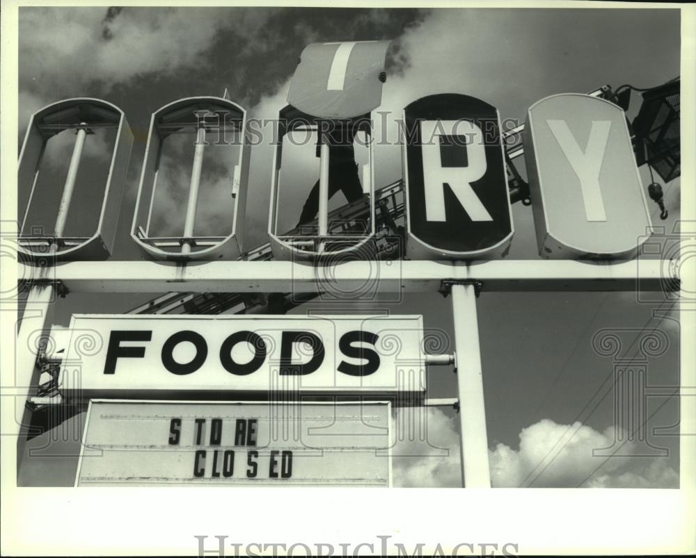 1994 Press Photo Chad Oslage removes letter from closing Sentry store, Oshkosh - Historic Images