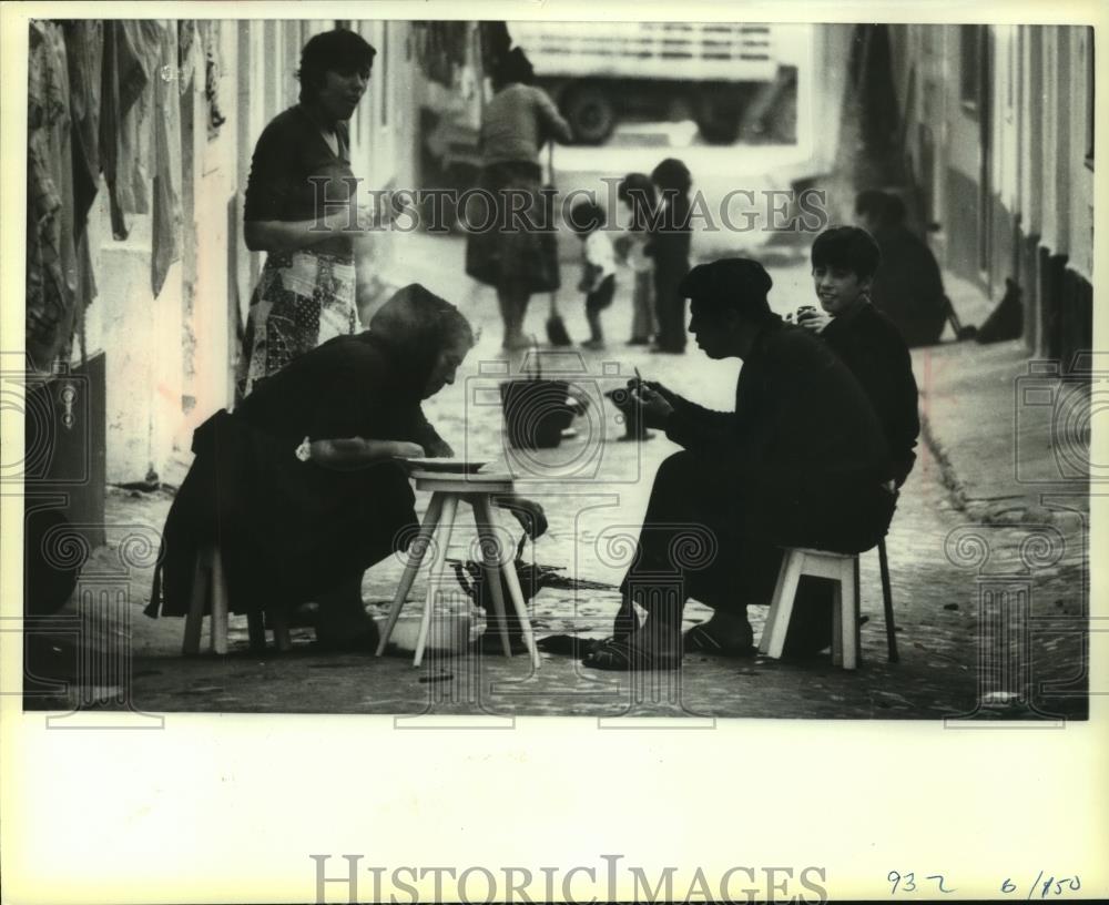 1980 Press Photo Family eat their lunchtime meal in street in Nazare, Portugal - Historic Images