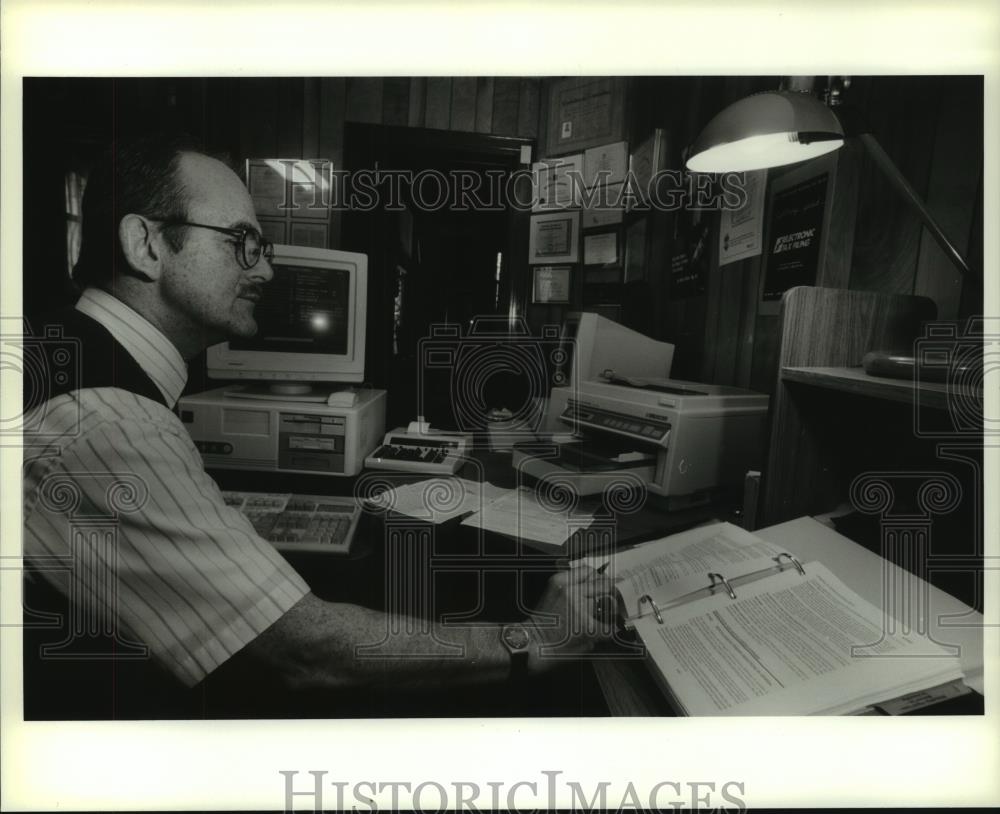 1995 Press Photo Tax preparer Rodrigo Diez works on customer&#39;s tax returns - Historic Images