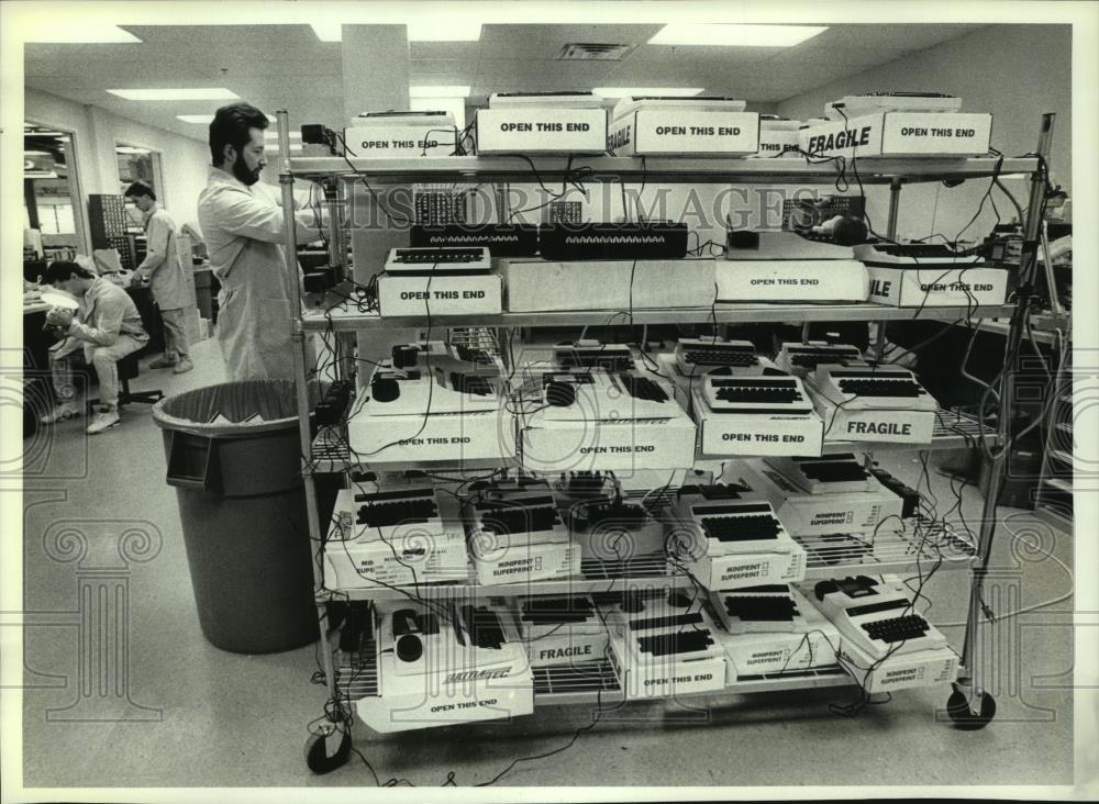 1991 Press Photo Ultratec employee Dave Tallman sets up equipment in Madison, WI - Historic Images