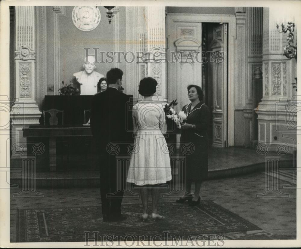 1980 Press Photo Russia state official gives a bouquet of flowers to newlyweds - Historic Images