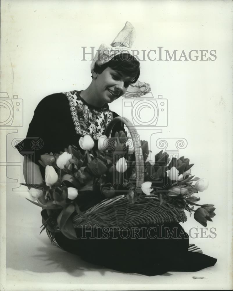 1982 Press Photo Woman in traditional Dutch costume holds a basket of tulips - Historic Images