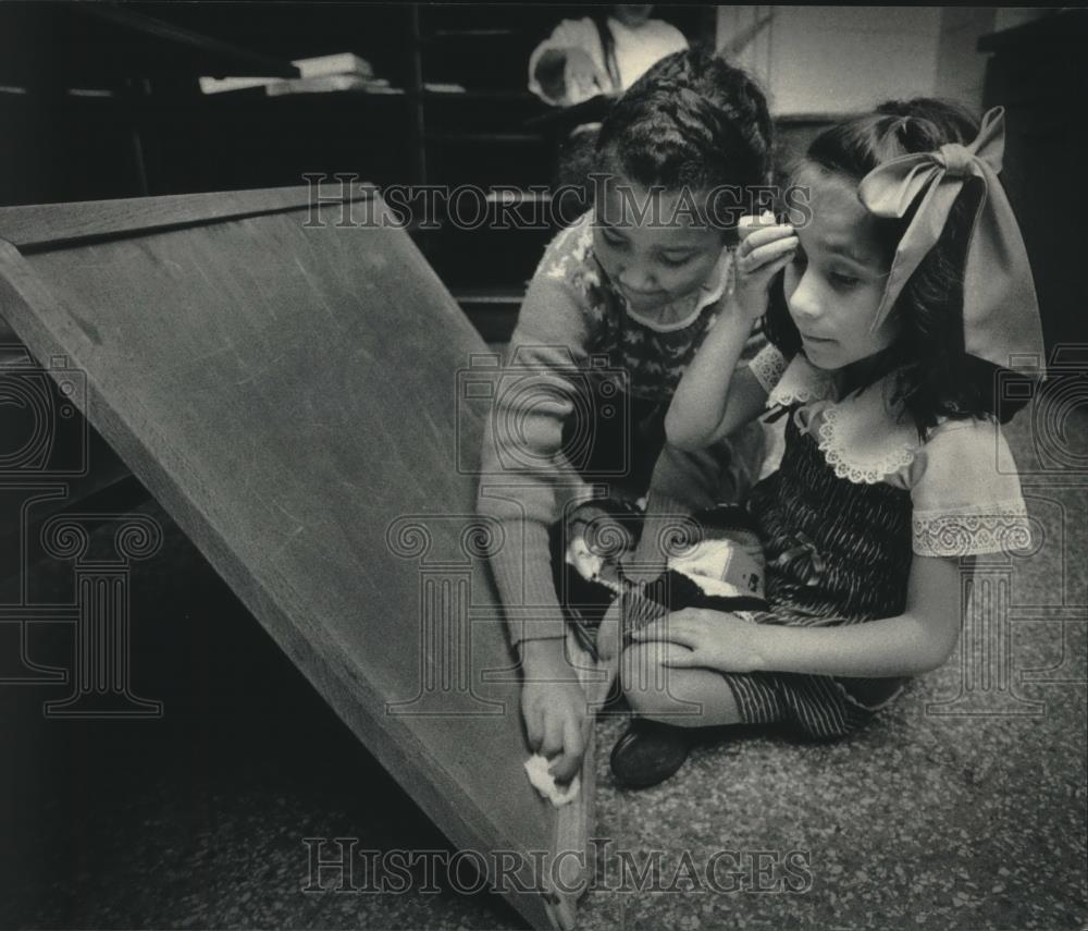 1985 Press Photo Rubby Ramos wipes chalkboard with Ruth Martinez at UCC - Historic Images