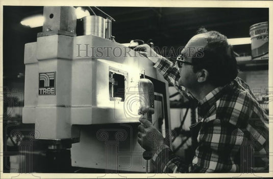 1986 Press Photo Michael Kozic examines Tree machine that was built in China - Historic Images