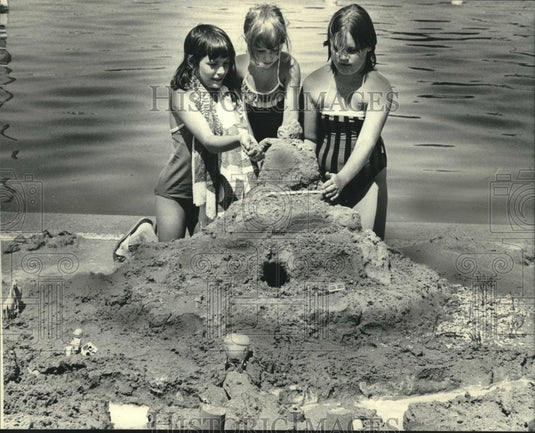 1983 Press Photo Girls finish their sand castle on Lac la Belle in Oconomowoc. - Historic Images
