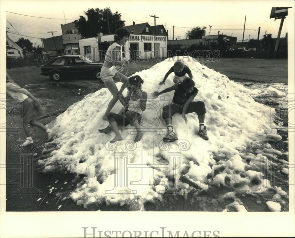 1987 Press Photo Passers-By Engage in Snowball Fight in Parking Lot, Milwaukee - Historic Images