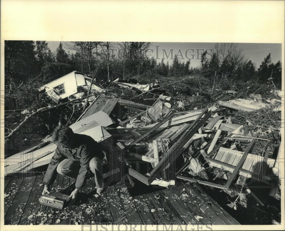 1984 Press Photo Pat Beaupre examines remains of her mobile home near Necedah - Historic Images