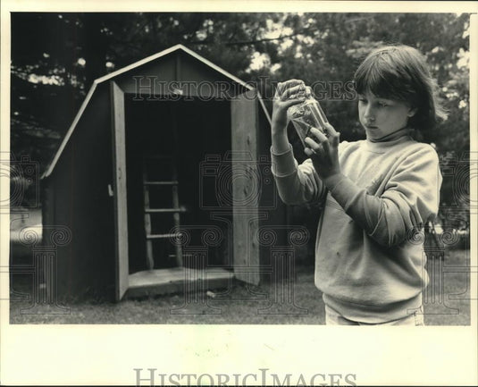 1987 Press Photo Laura Stiebs, 9, checks out a bug caught on Miner Lake. - Historic Images