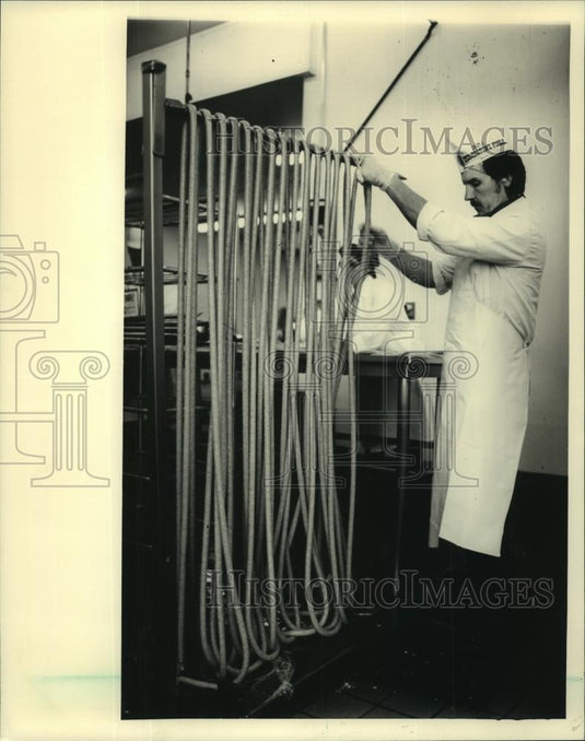 1986 Press Photo Dave Butkus worked with a sausage at Tombstone Pizza Inc. - Historic Images