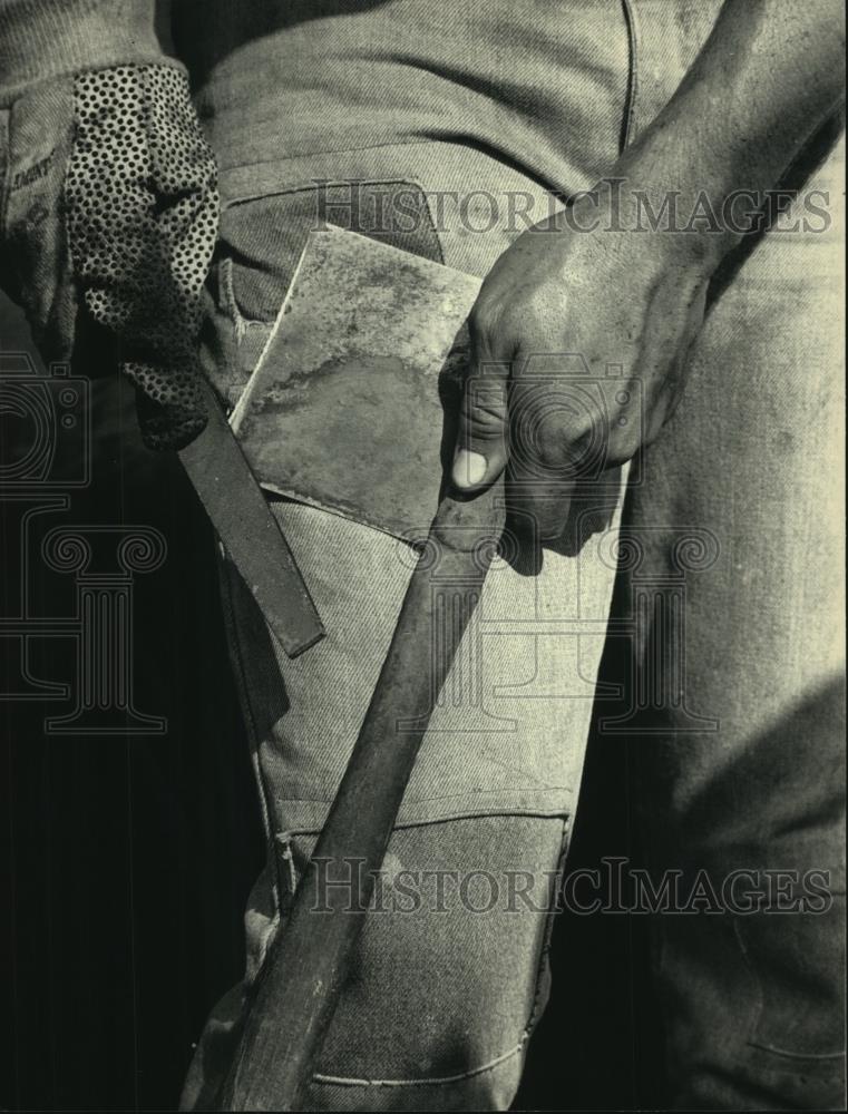 1986 Press Photo Tobacco ax is sharpened before field use in Edgerton, Wisconsin - Historic Images