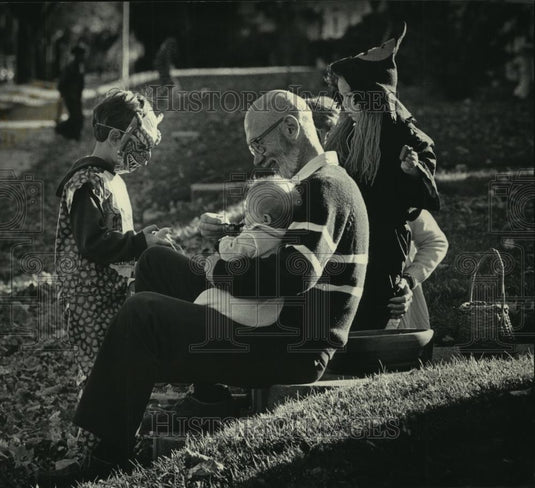 1985 Press Photo Ron Berg and his granddaughters greeted trick and treaters. - Historic Images
