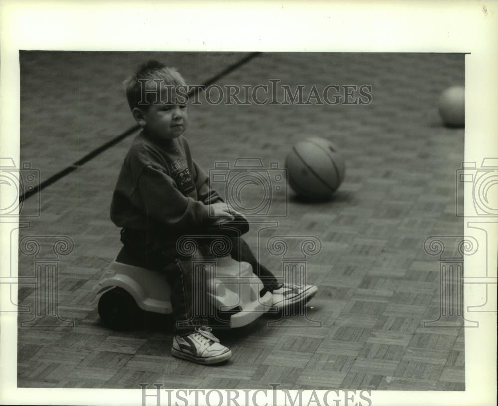 1994 Press Photo A toddler riding a low-to-the-ground riding toy, helps skills. - Historic Images