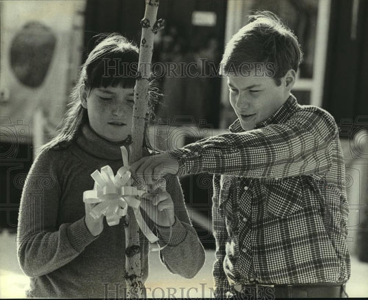 1981 Press Photo Julie, Jeff Christenson, ties ribbon at Barbara Timm's home - Historic Images