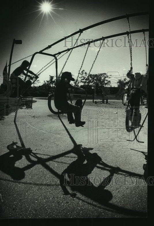 1982 Press Photo Children silhouetted against a bright sun at Tiefenthaler Park - Historic Images