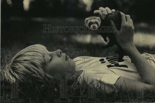 1983 Press Photo A boy sharing a summer day with his pet ferret. - mjc12850 - Historic Images