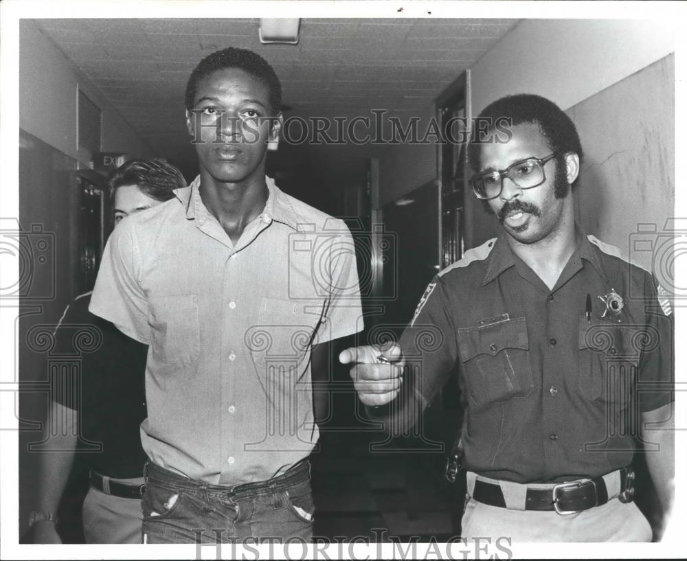 1981 Press Photo Frank Marie Harris walks with police officers in hallway - Historic Images