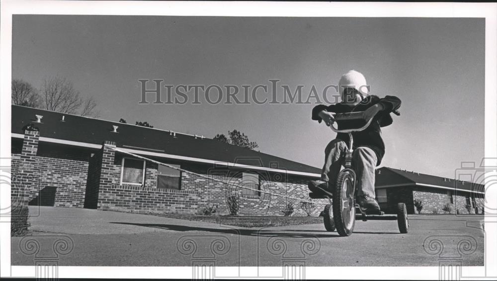 1986 Press Photo Josh Jones Rides Tricycle at Apartment Where Murder Occurred - Historic Images