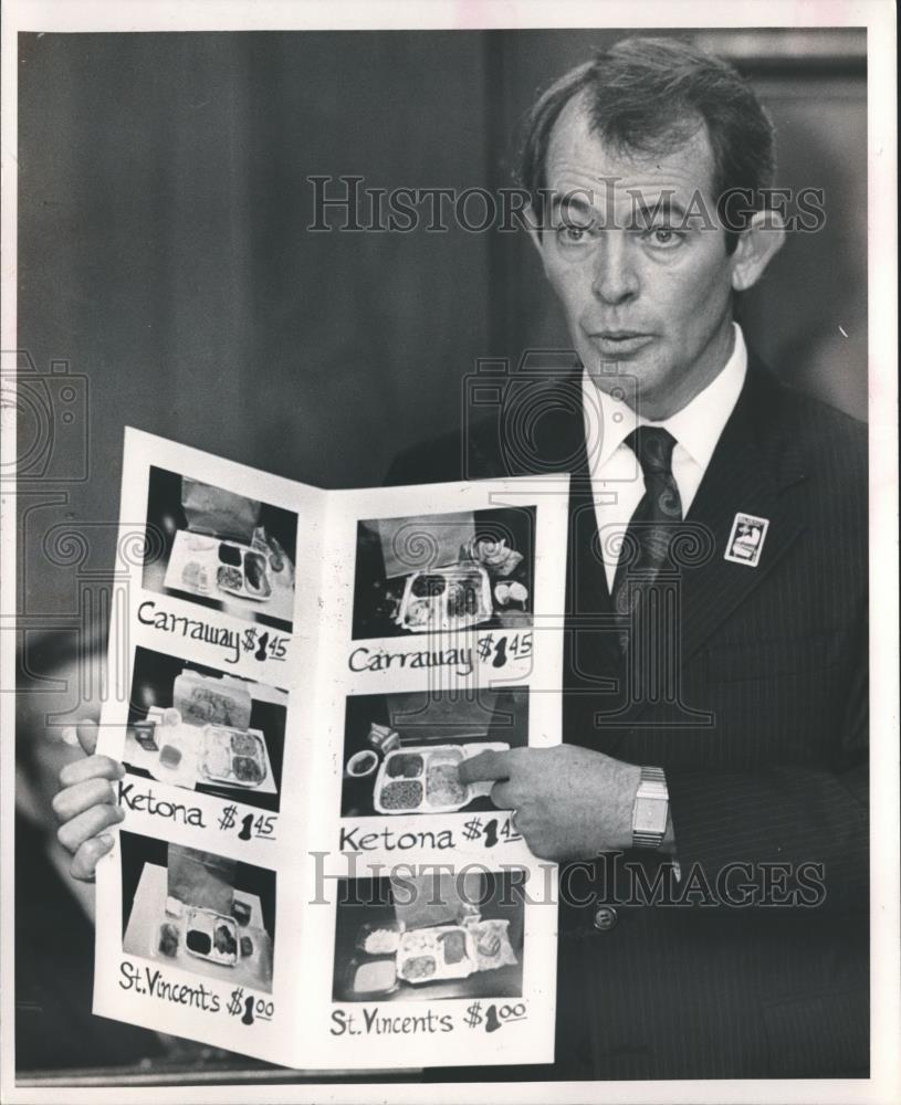 1989 Press Photo County Commissioner Jim Gunter displays a poster showing meals - Historic Images