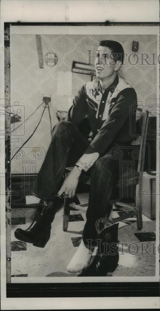 Press Photo Wes Santee putting on cowboy boots - abns06724 - Historic Images