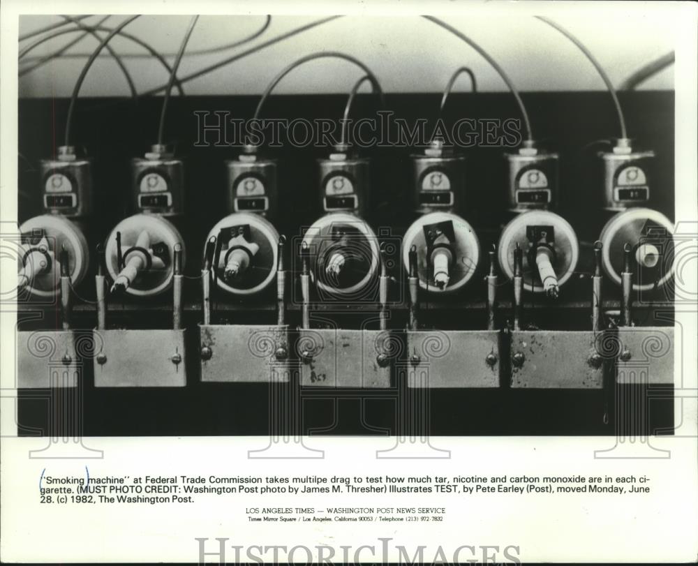 1982 Press Photo A smoking machine at Federal Trade Commission tests cigarettes. - Historic Images