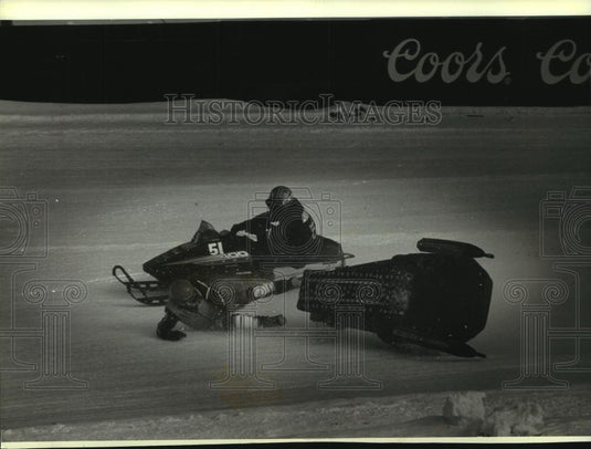 1988 Press Photo Gerald Dyrdahl flips snowmobile and almost struck, Eagle River. - Historic Images
