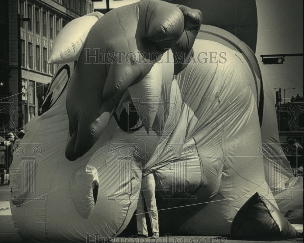 1986 Press Photo A handler holding a inflated rocking horse in wind, Milwaukee. - Historic Images