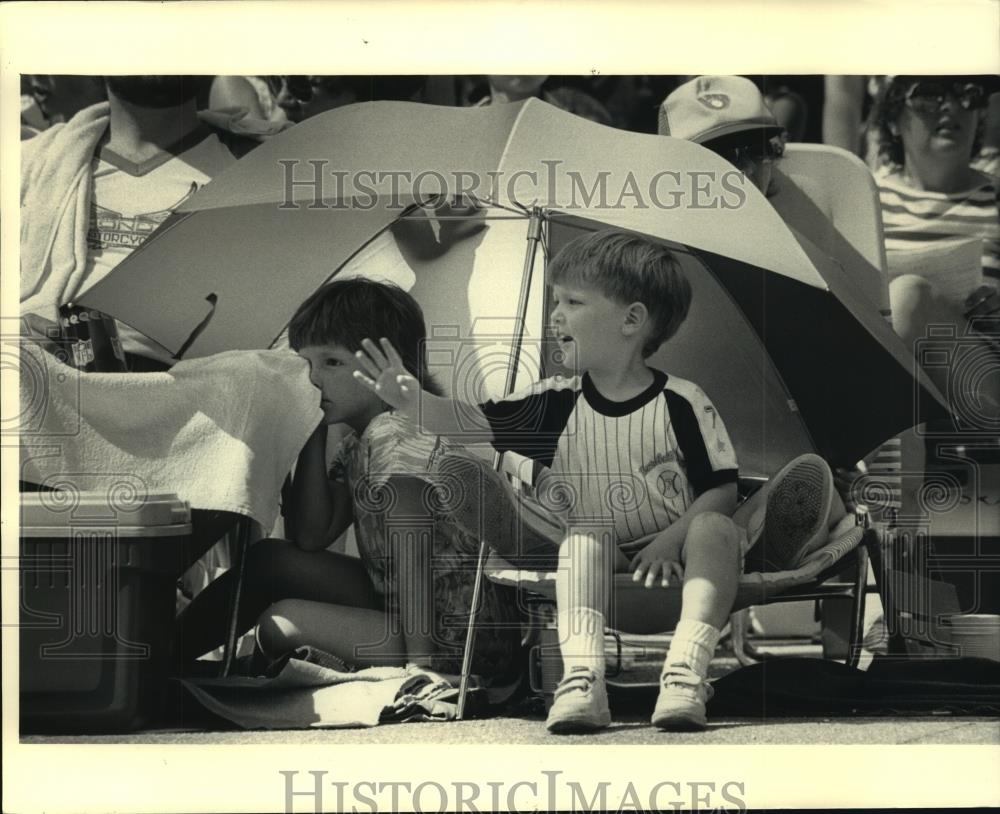 1986 Press Photo Sabrina Kloc and brother under umbrella at Parade, Milwaukee. - Historic Images