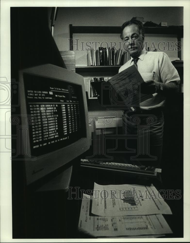 1990 Press Photo Robert Snow looks over computer-generated reports in Wisconsin - Historic Images