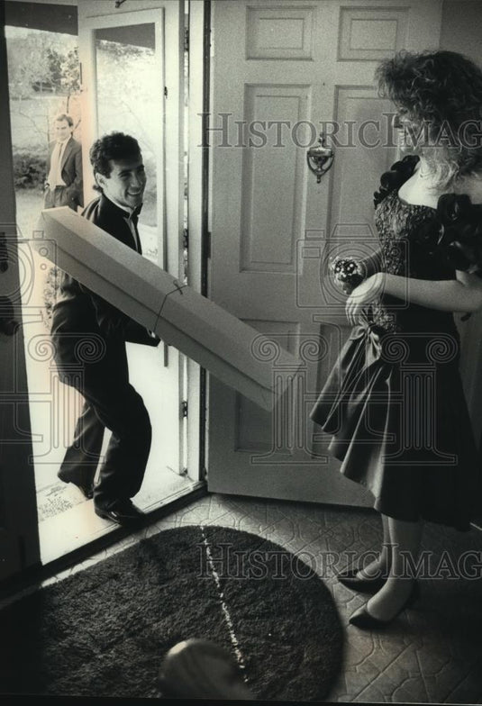 1990 Press Photo Gino Lambo handing Sarah Cornwell a box of flowers for prom. - Historic Images