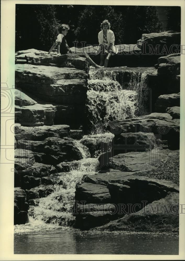 1985 Press Photo Haertel and Sloane put feet in man-made waterfall Wauwatosa - Historic Images