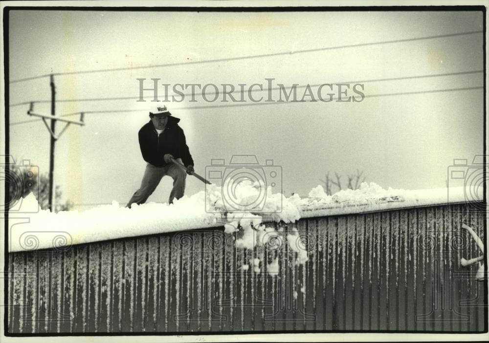 1993 Press Photo Domingo Ramirez shovels wet snow from a roof in Wisconsin - Historic Images