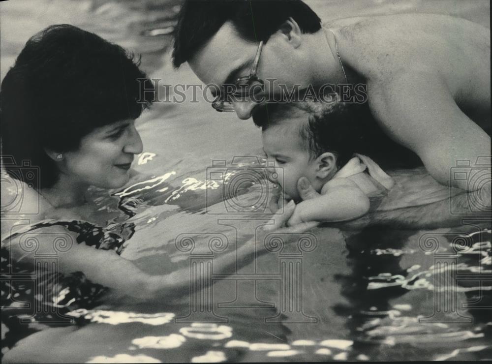 1984 Press Photo Richard and Jo Ellen Hartman swimming with daughter. - Historic Images