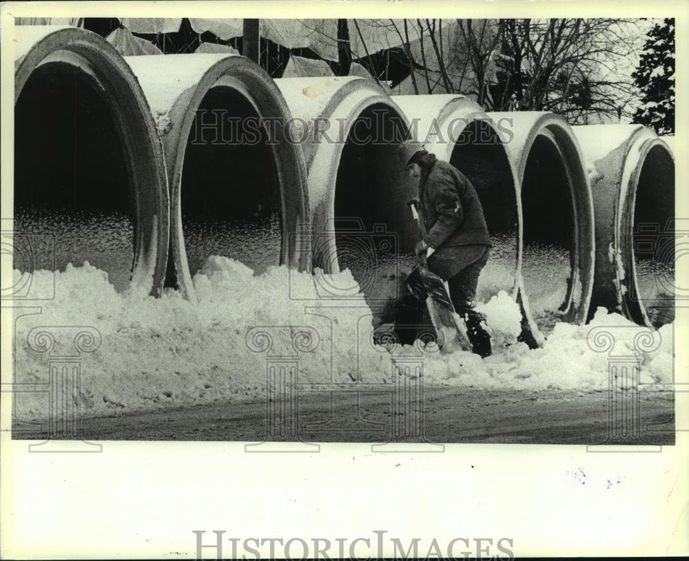 1982 Press Photo Wisconsin sewer construction worker shovels snow from pipes - Historic Images